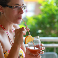 Frau im Bikini trinkt aus einem Cocktailglas im Gastronomiebereich des Familienbads LA OLA 