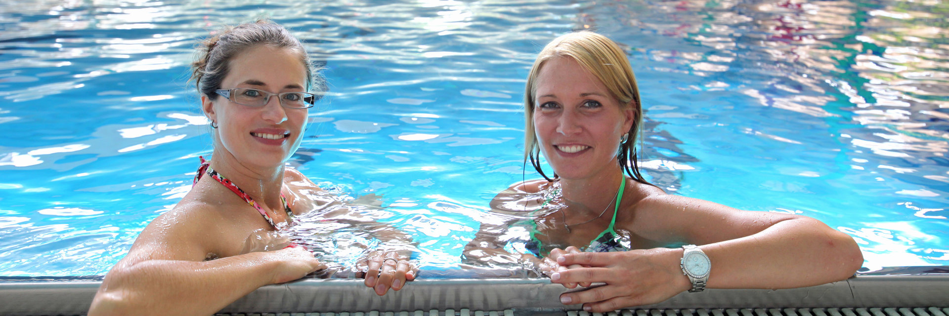 zwei Frauen machen am Beckenrand vom Schwimmerbecken eine Pause im freizeitbad laola